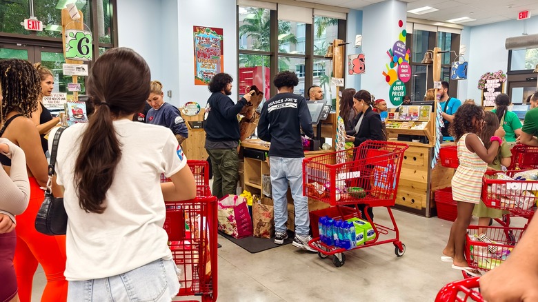 Busy checkout section in  Trader Joe's with lots of people waiting
