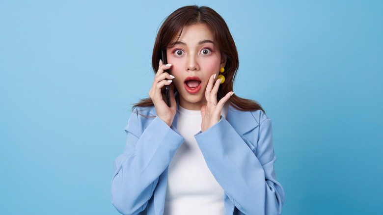Woman making a surprised expression while talking on the phone