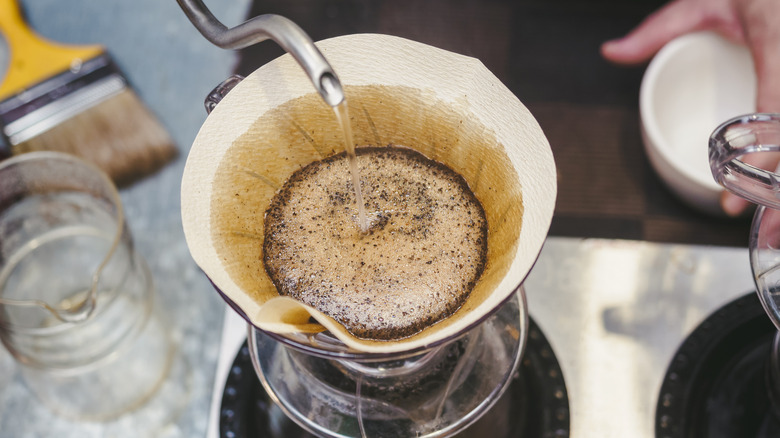 Water is poured into coffee grounds in a pour-over filter