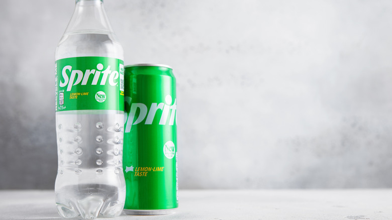 A can and bottle of Sprite on a white table top