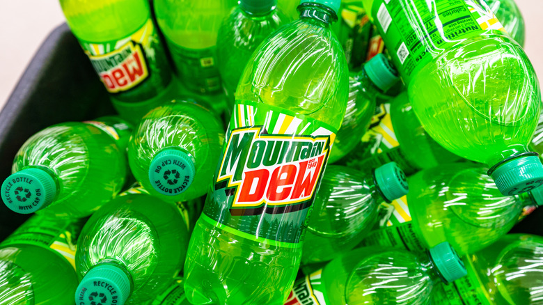 Bottles of Mountain Dew piled in a black bin