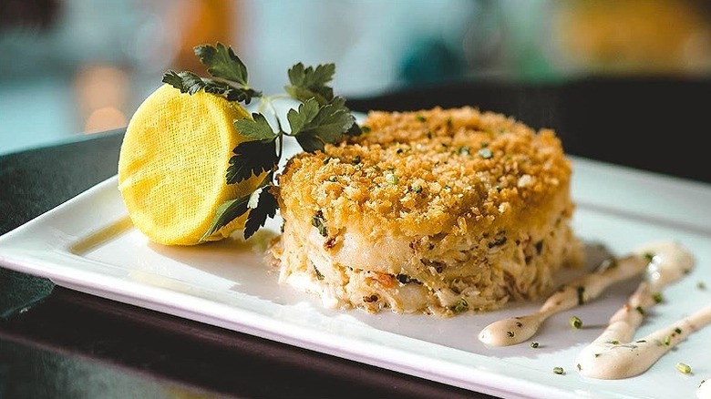 A crab cake sits on a white plate at Eddie V's Prime Seafood