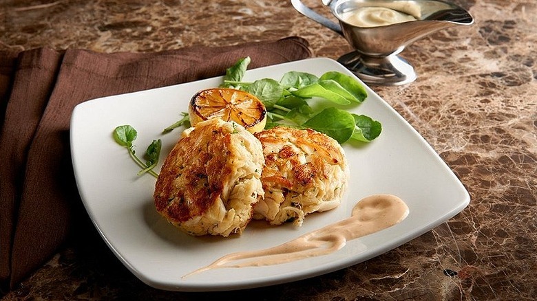 Two crab cakes sit on a white plate at Morton's the Steakhouse