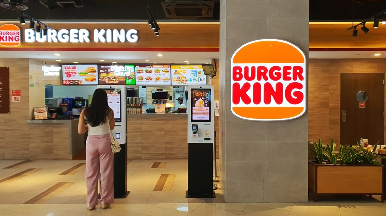 A young girl ordering a Burger King meal at the self-service kiosk