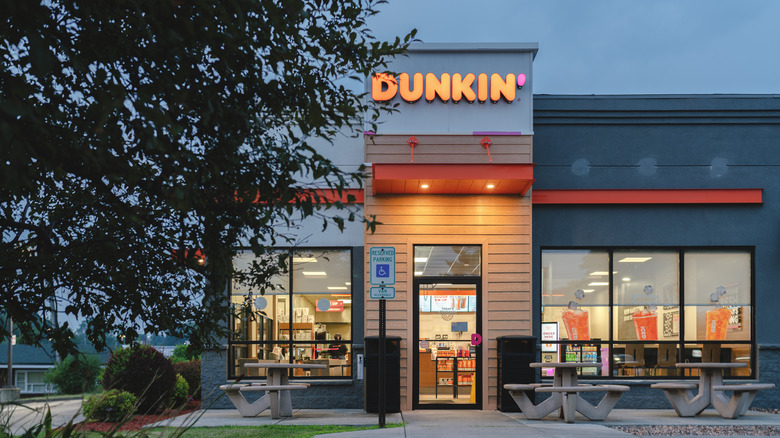 The exterior of Dunkin' lit up in the evening