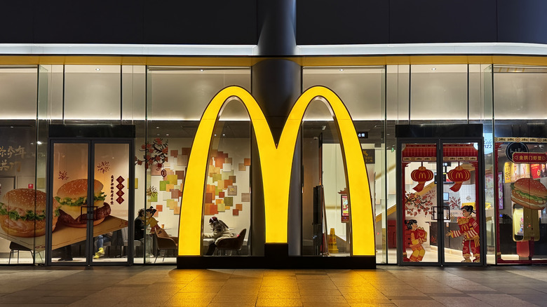 A golden arches neon sign outside of a McDonald's