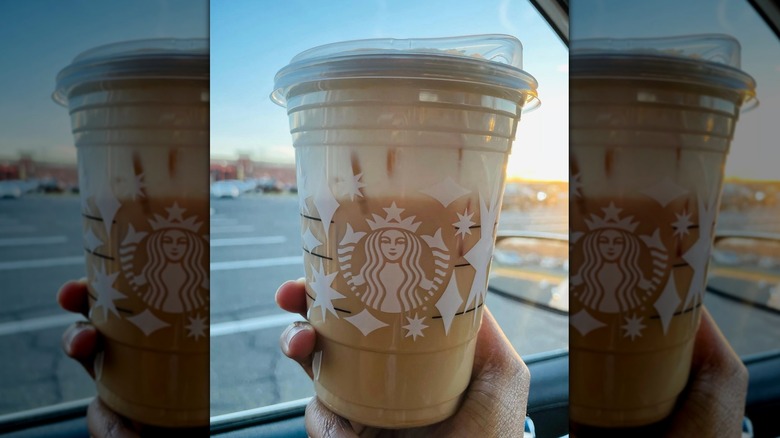 Hand holding a Starbucks Iced Chai Latte with Cold Foam