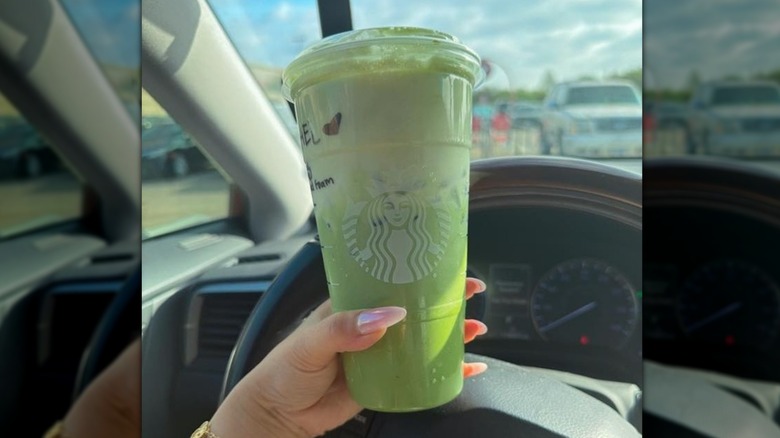 Hand holding Iced Matcha Latte