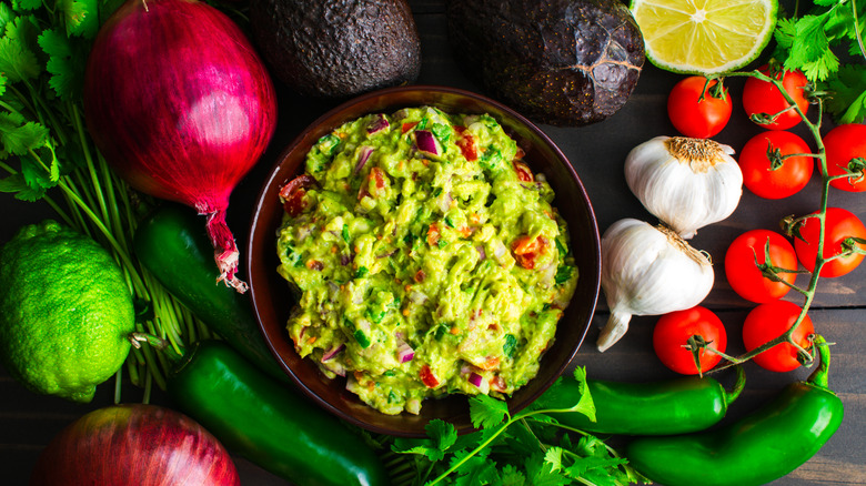 Homemade guacamole surrounded by vegetables