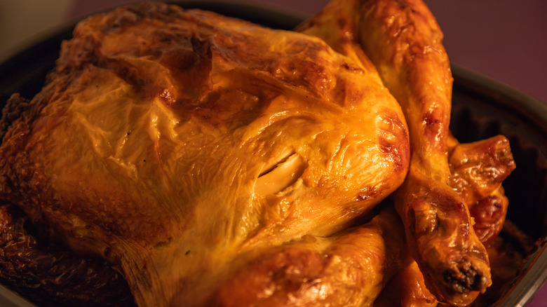 a rotisserie chicken with broken skin