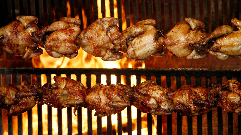 rotisserie chickens cooking in an oven