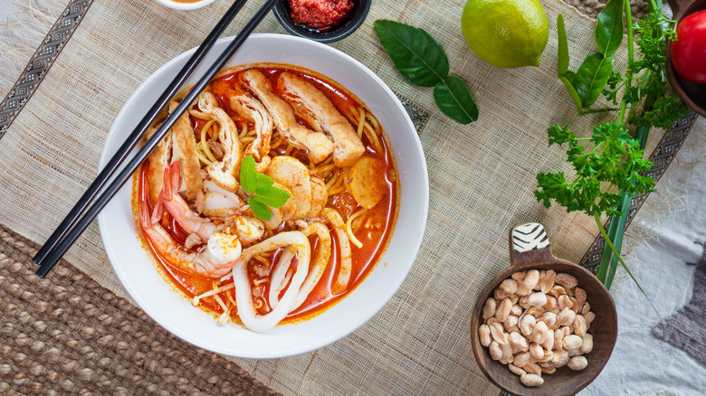 White bowl of laksa noodles with black chopsticks