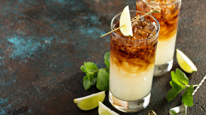 Two dark and stormy cocktails with lime wedge garnishes