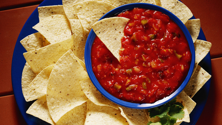 Blue platter with tortilla chips and a blue bowl of salsa