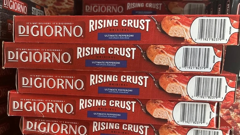 Freezer shelf containing stacked boxes of DiGiorno Rising Crust Ultimate Pepperoni frozen pizza