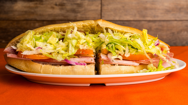An Italian sub on a plate on a red table