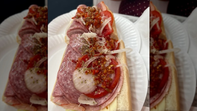An open sub with salami, onions, and peppers on a white plate from White House sub