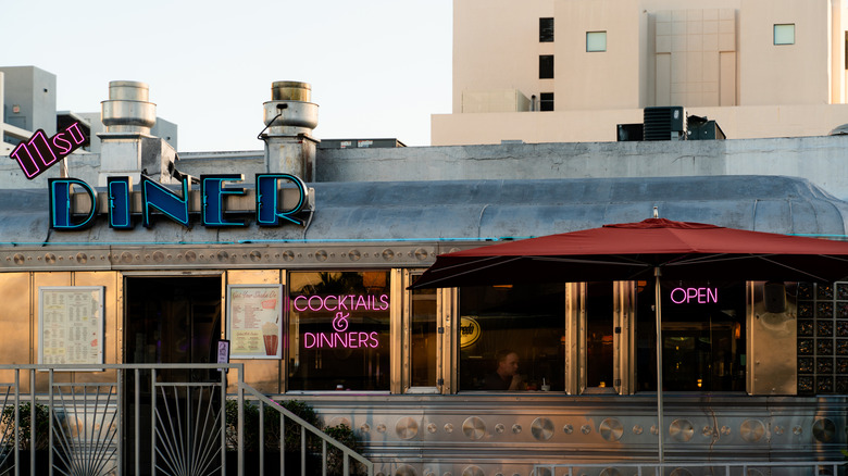 The exterior of 11th Street Diner in the daytime, it has pink and blue neon signs