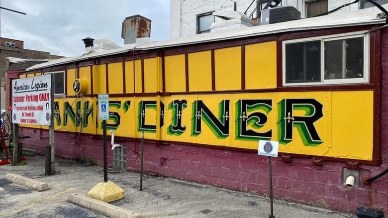 The exterior of Franks Diner, it is yellow with vintage green lettering painted on the walls that write "Frank's Diner"