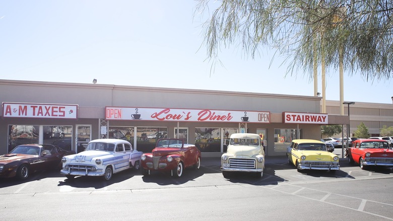 A sunny exterior of Lou's Diner with classic cars parked out front