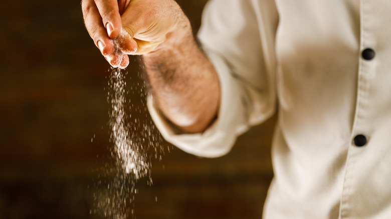 a chef salting a dish