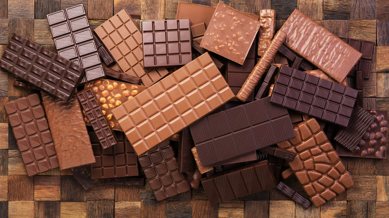 An assortment of unwrapped chocolate bars on a wooden surface