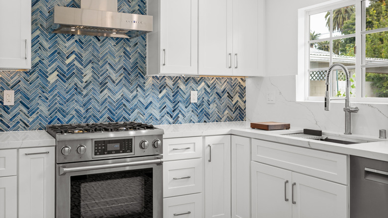 Contemporary white kitchen with blue geometric tile backsplash