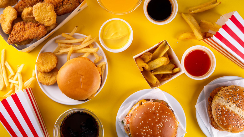 Hamburgers, chicken nuggets, and fries on a yellow background
