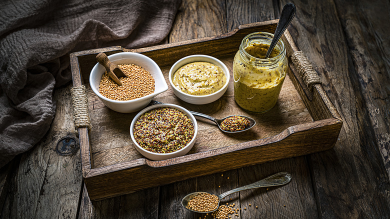assorted mustards in jars and bowls