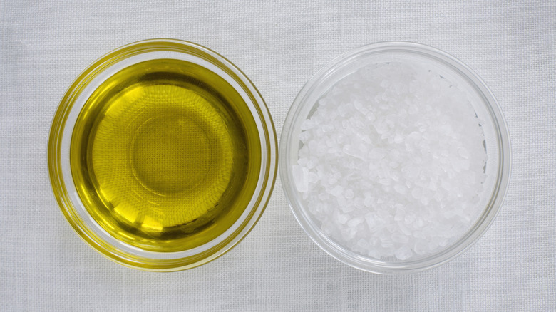 Clear side by side bowls of olive oil and salt