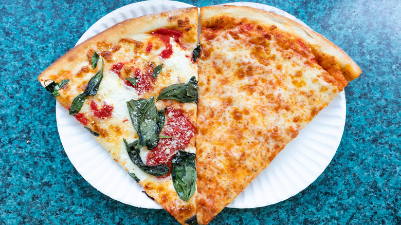 Giant slices of New York pizza on white plates
