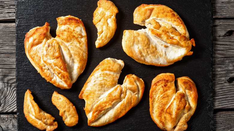 Various butterflied chicken breasts, seared golden on a plate