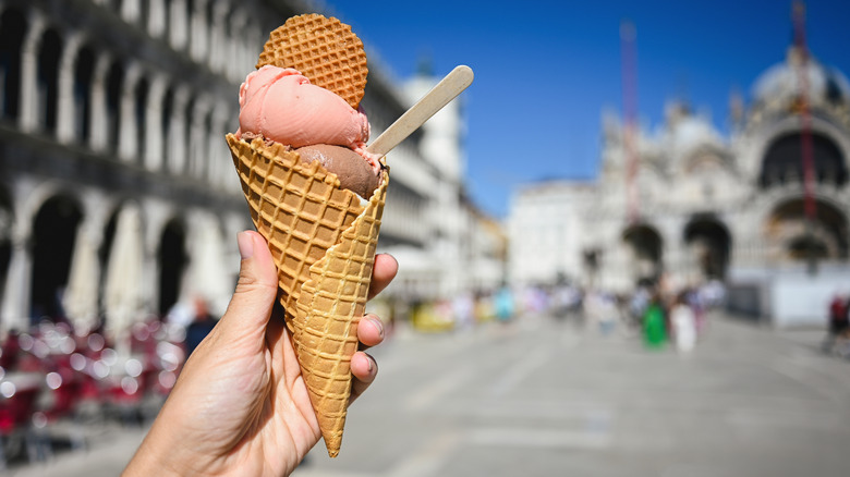 hand holding ice cream in waffle cone