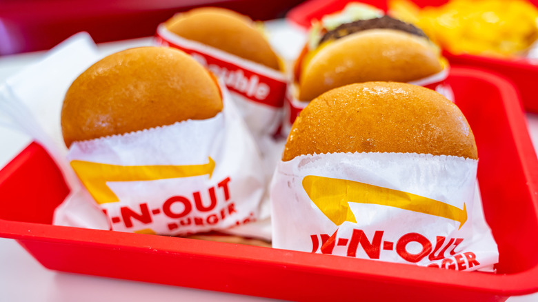 Four In-N-Out burgers in a red tray.