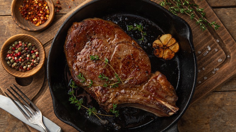 steak in a cast iron skillet with fresh thyme and garlic