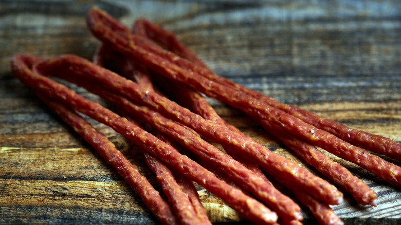 A pile of meat sticks on a wooden table