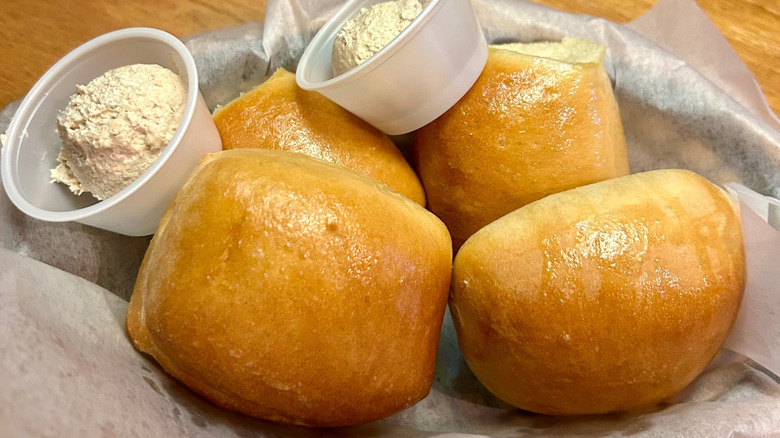 A basket of Texas Roadshouse rolls with butter