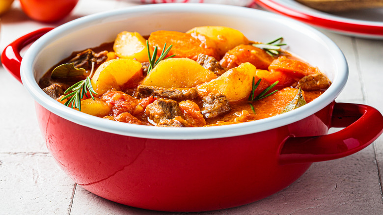 Beef stew with potatoes and carrots in a red pot