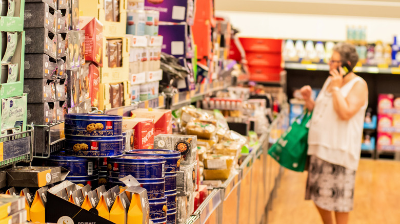 A person is looking at groceries on the shelf at Aldi.