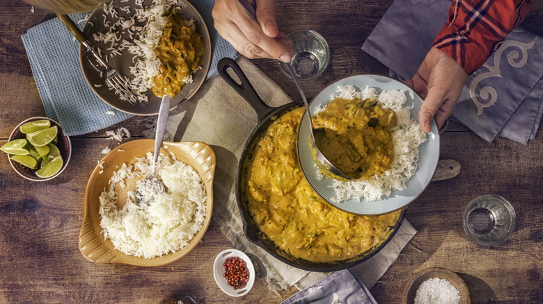 curry over plate of rice on wooden table