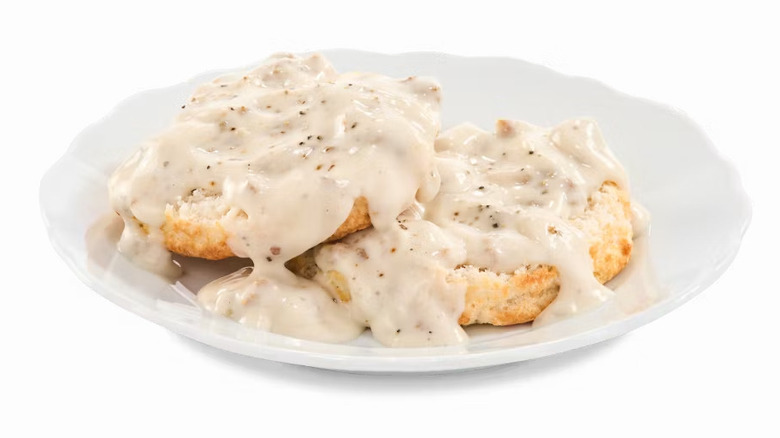 Plate of Bojangles biscuits and gravy against a white background.