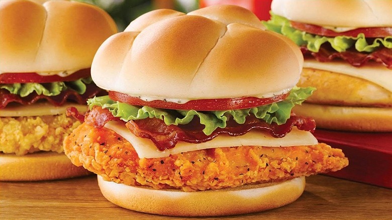 A spicy asiago ranch chicken club at Wendy's sits next to two other chicken clubs