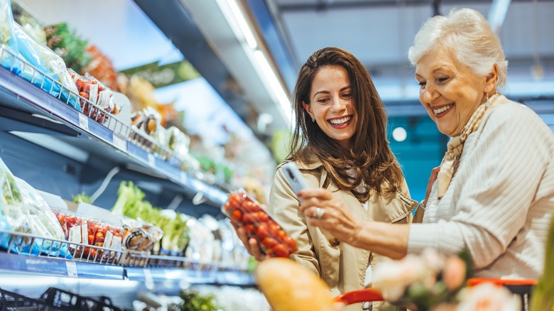 older and younger women shopping together in a grocery store,