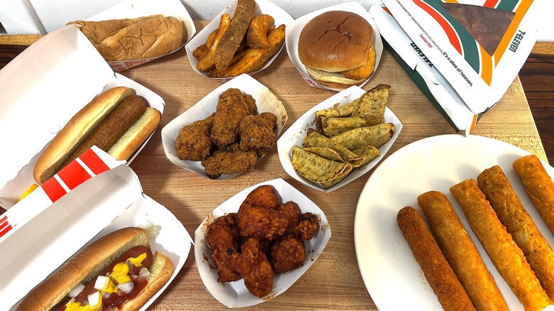 Various hot foods from 7-Eleven are spread out on a table