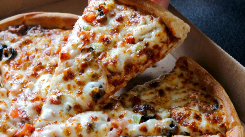 A slice of Godfather's signature pizza lifted from the box.