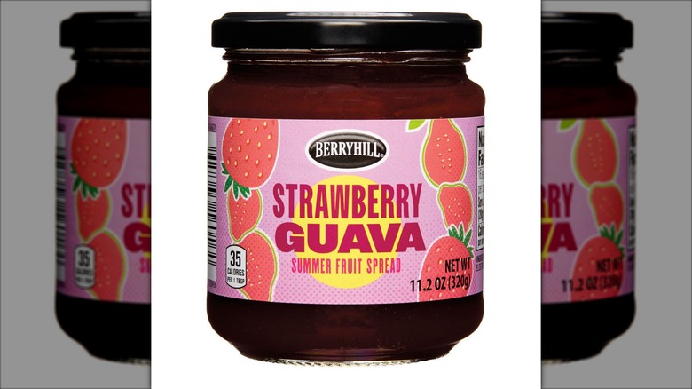 A jar of berry spread sits against a white background.