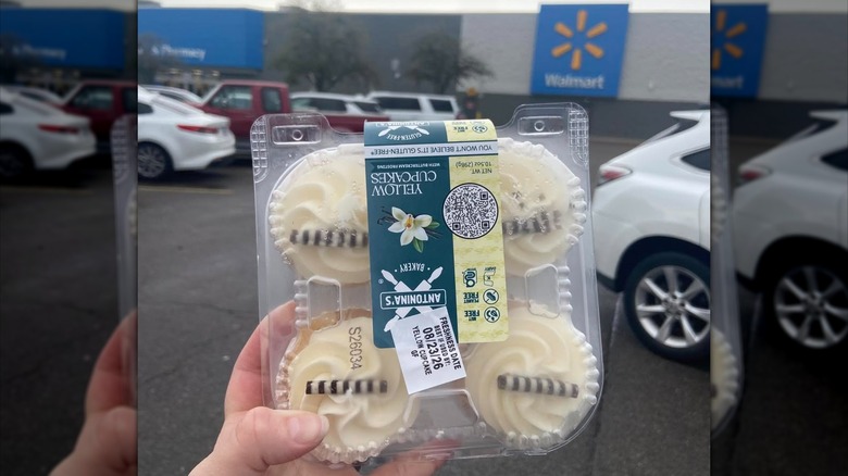 Hand holding package of Antonia's cupcakes in Walmart parking lot