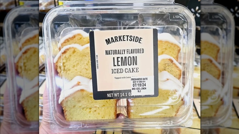 Hand holding package of Marketside Lemon Cake