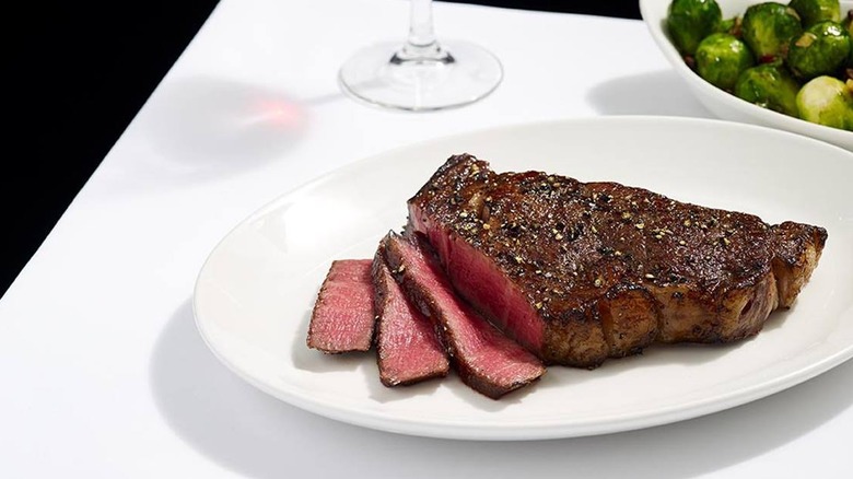 Del Frisco's Double Eagle Steakhouse Dry-Aged Strip sliced up on a plate.