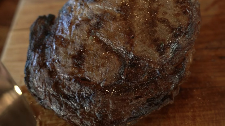 Close-up of Fogo de Chão Dry-Aged Tomahawk being prepared.